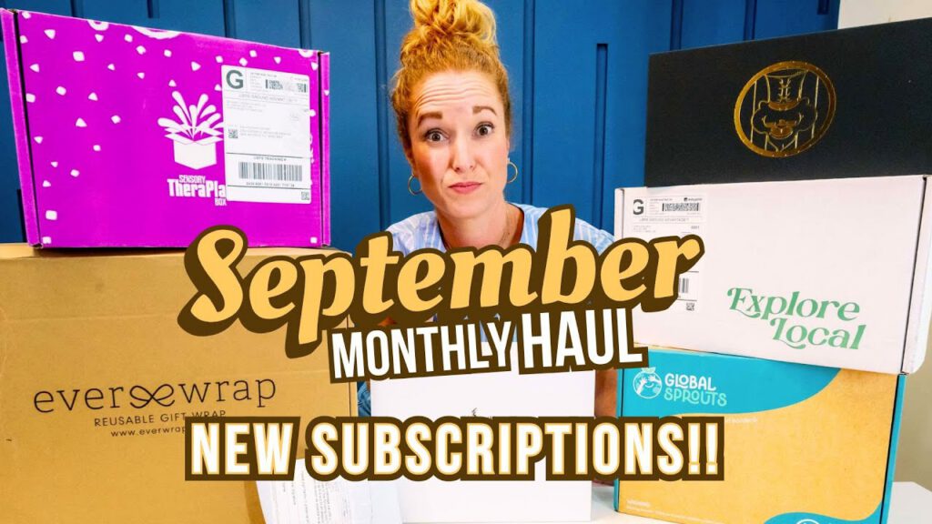 A woman showcases subscription boxes for September 2025, highlighting new arrivals and cozy-season items.
