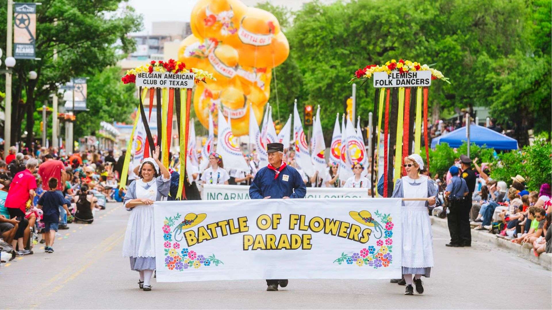 Colorful parade with floats and participants celebrating the Battle of Flowers in San Antonio.